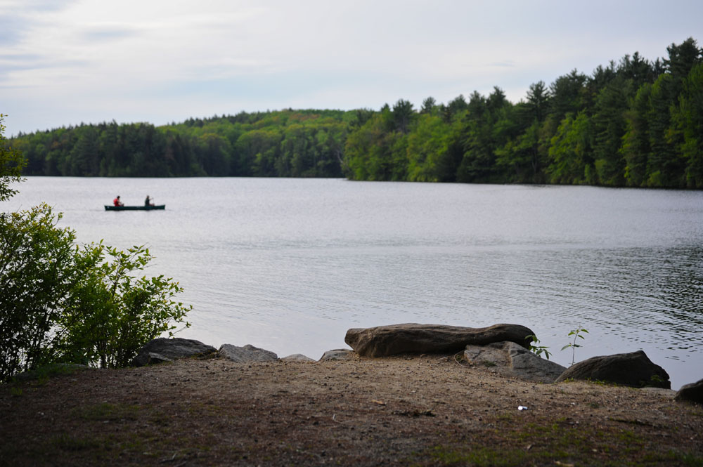 two small boats are floating on the water near rocks