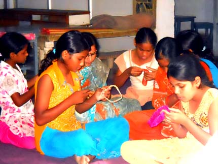 girls sitting on the floor playing with their mobile phones