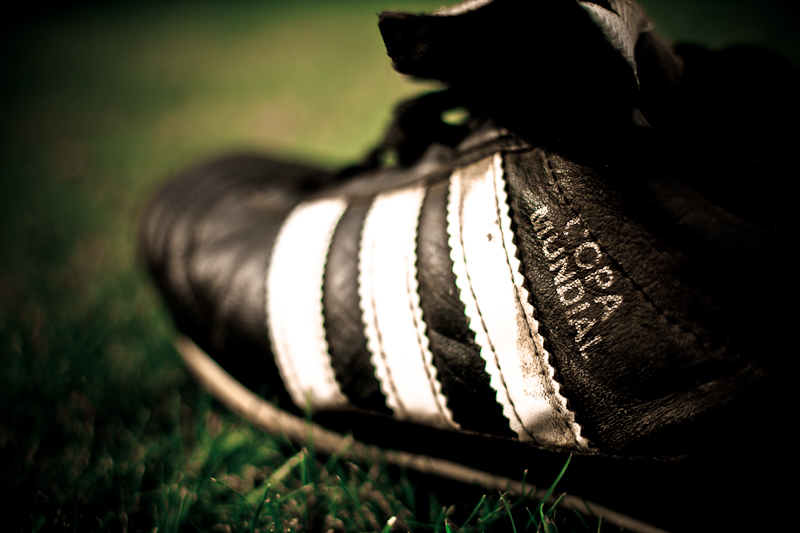 a worn soccer shoe sitting in the grass
