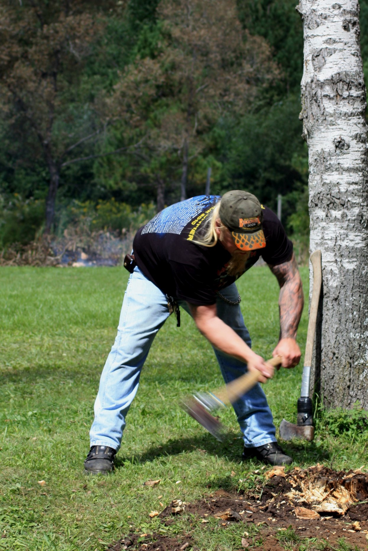 a man working in the grass with a big hammer