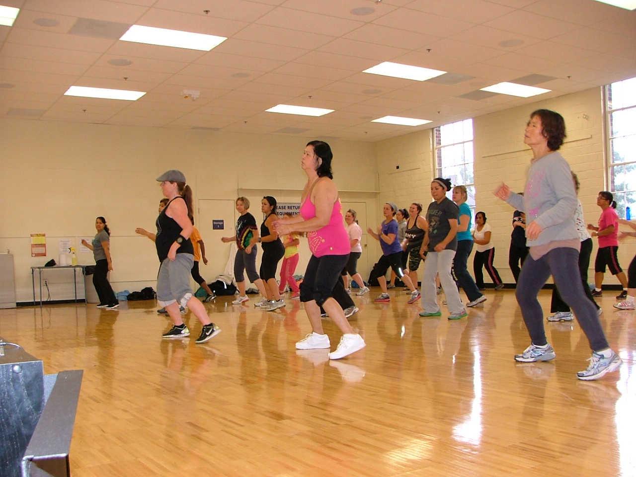 some girls are dancing on the hardwood floor in a gym