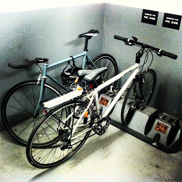 a couple of bicycles parked against a wall in a public room