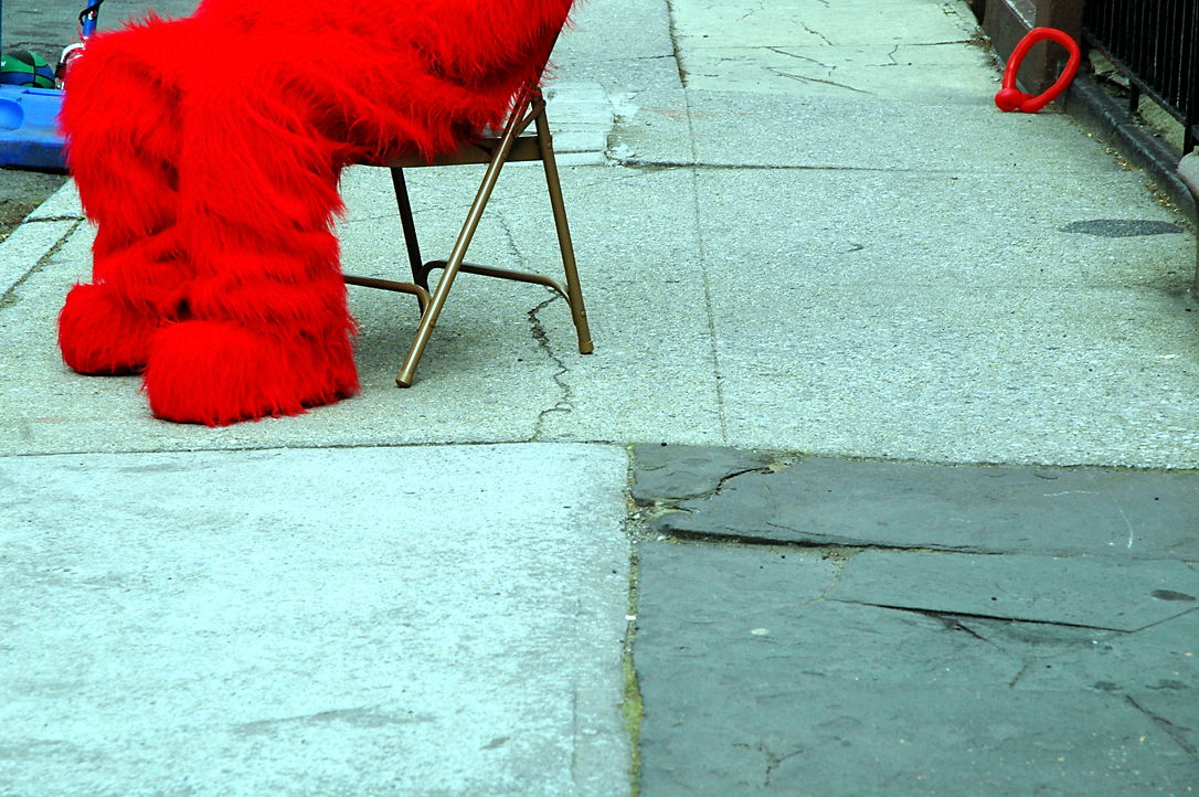 red and black chair and chairs on a sidewalk