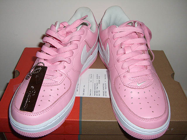 a pair of pink tennis shoes on top of a box