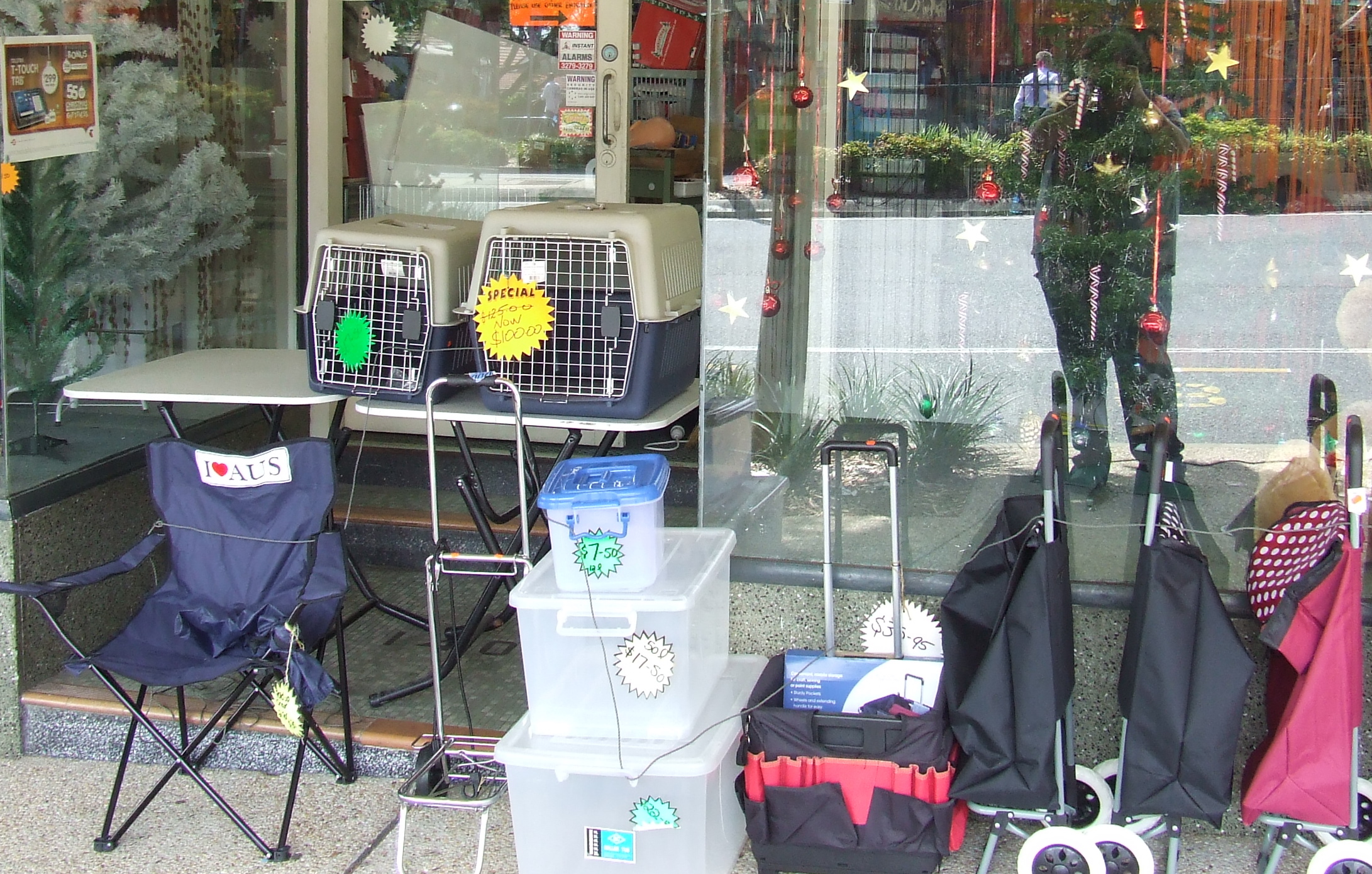 luggage in front of a store with baskets, umbrellas and other supplies on the front