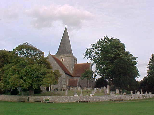 a church with a red brick tower in a cemetery