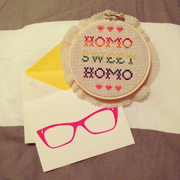 a cross stitch pillow with some items that say hou - o, sweet bromo, and pink glasses