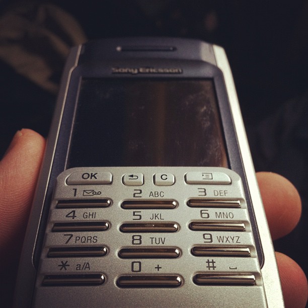 a cell phone in a persons hand showing the time and date