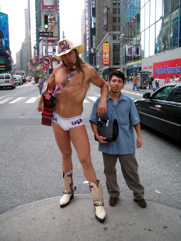 a man standing on the side of a street in underwear and sandals