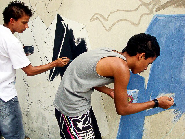 a young man is painting a wall with blue and white paint