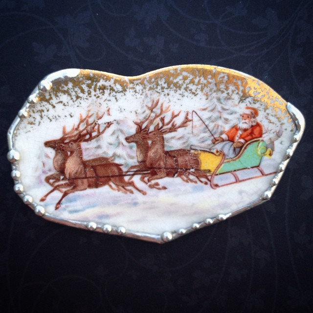 a porcelain plate decorated with santa and reindeers pulling a sleigh through the snow