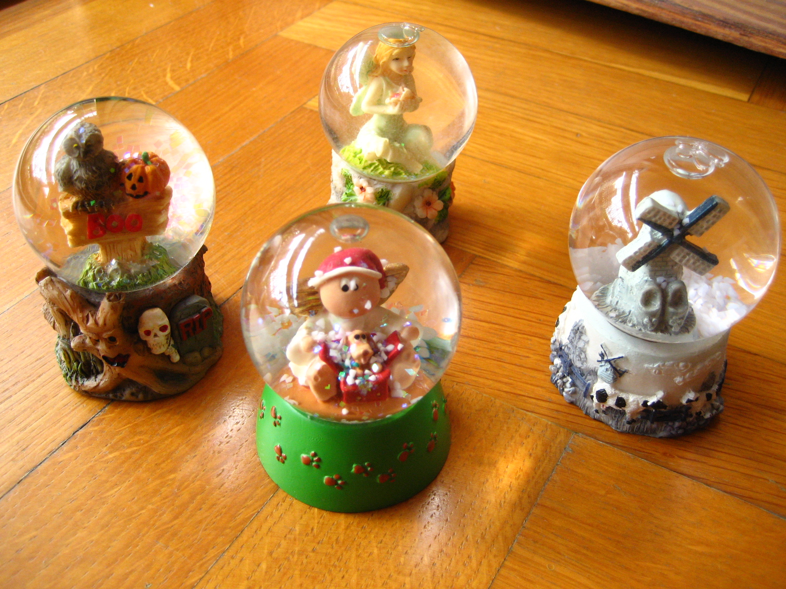 several snow globes, one depicting various christmas items