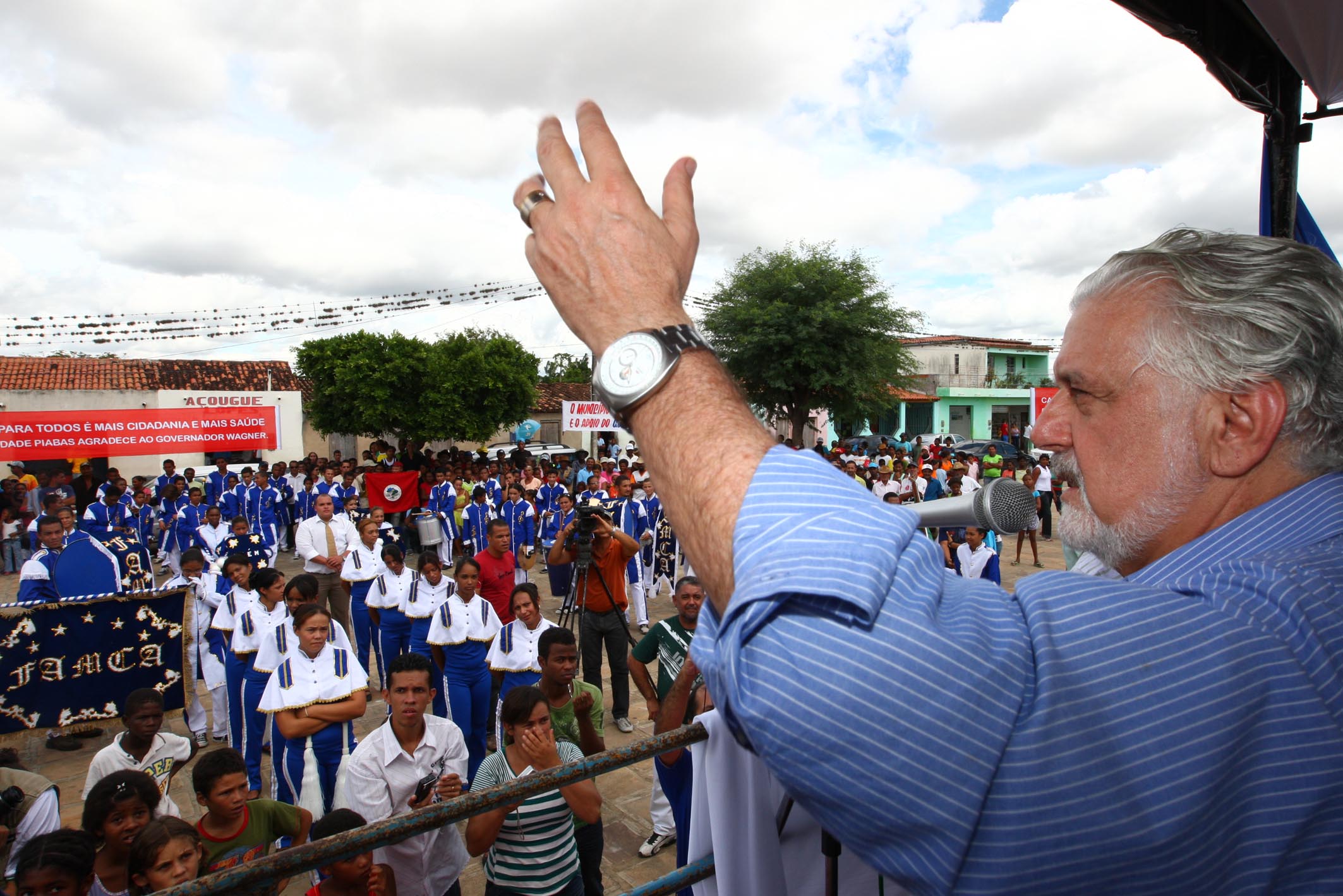 an older man raises his hand in a crowd