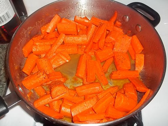 a close up of a pan with carrots in oil