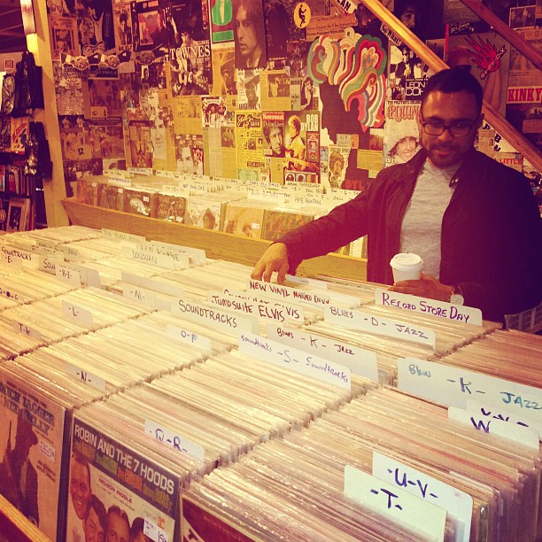 a man that is standing next to some records