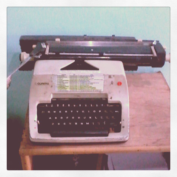 old typewriter with keyboard on small wooden table