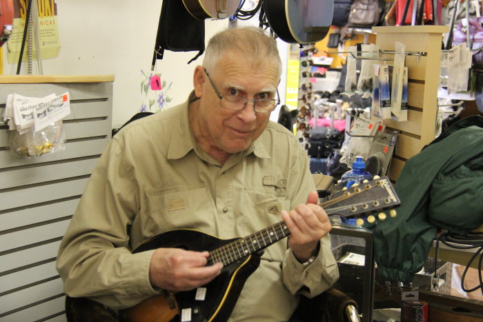 an old man is playing a guitar inside