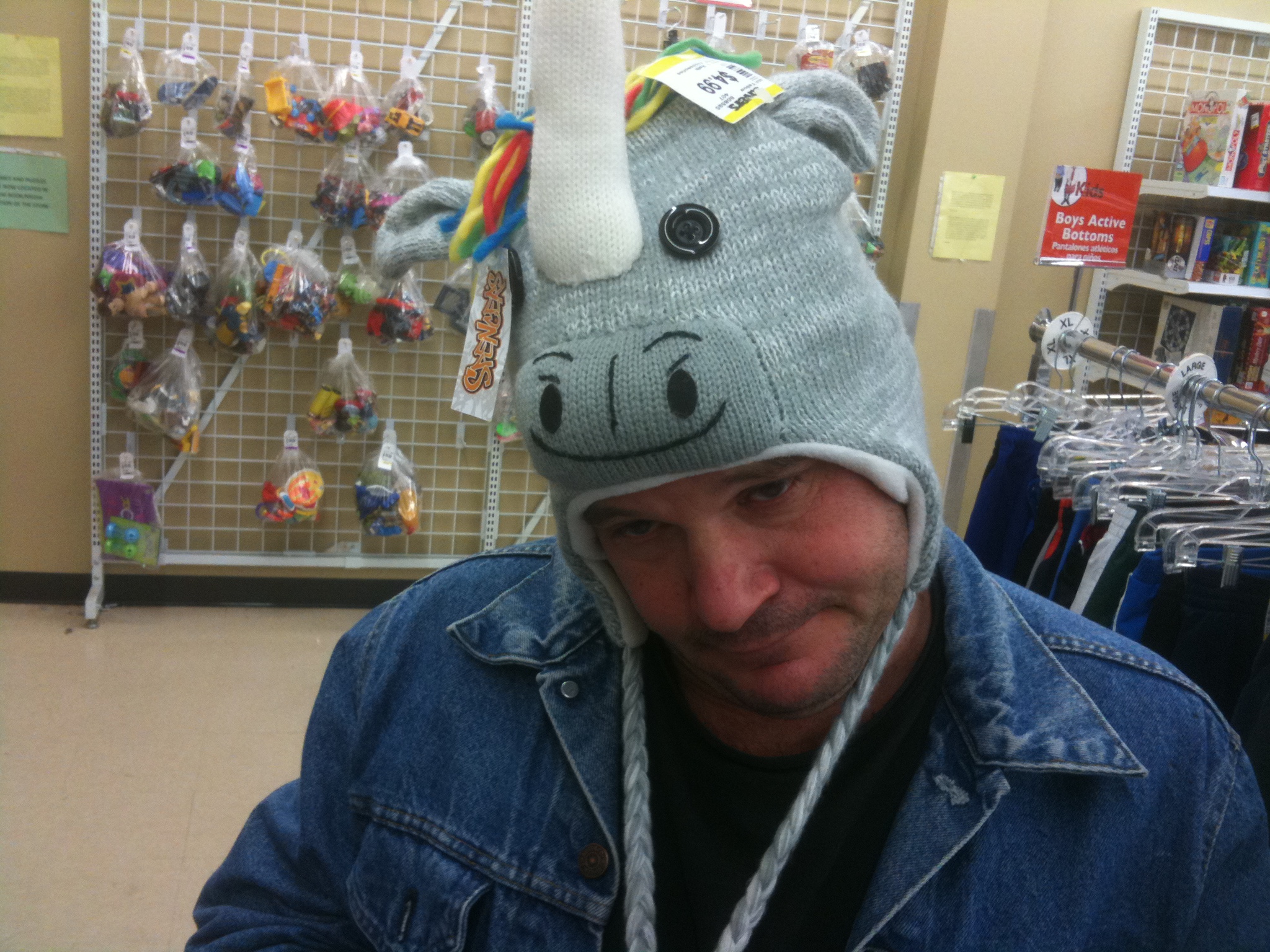 a man wearing a knit hat with a funny unicorn face
