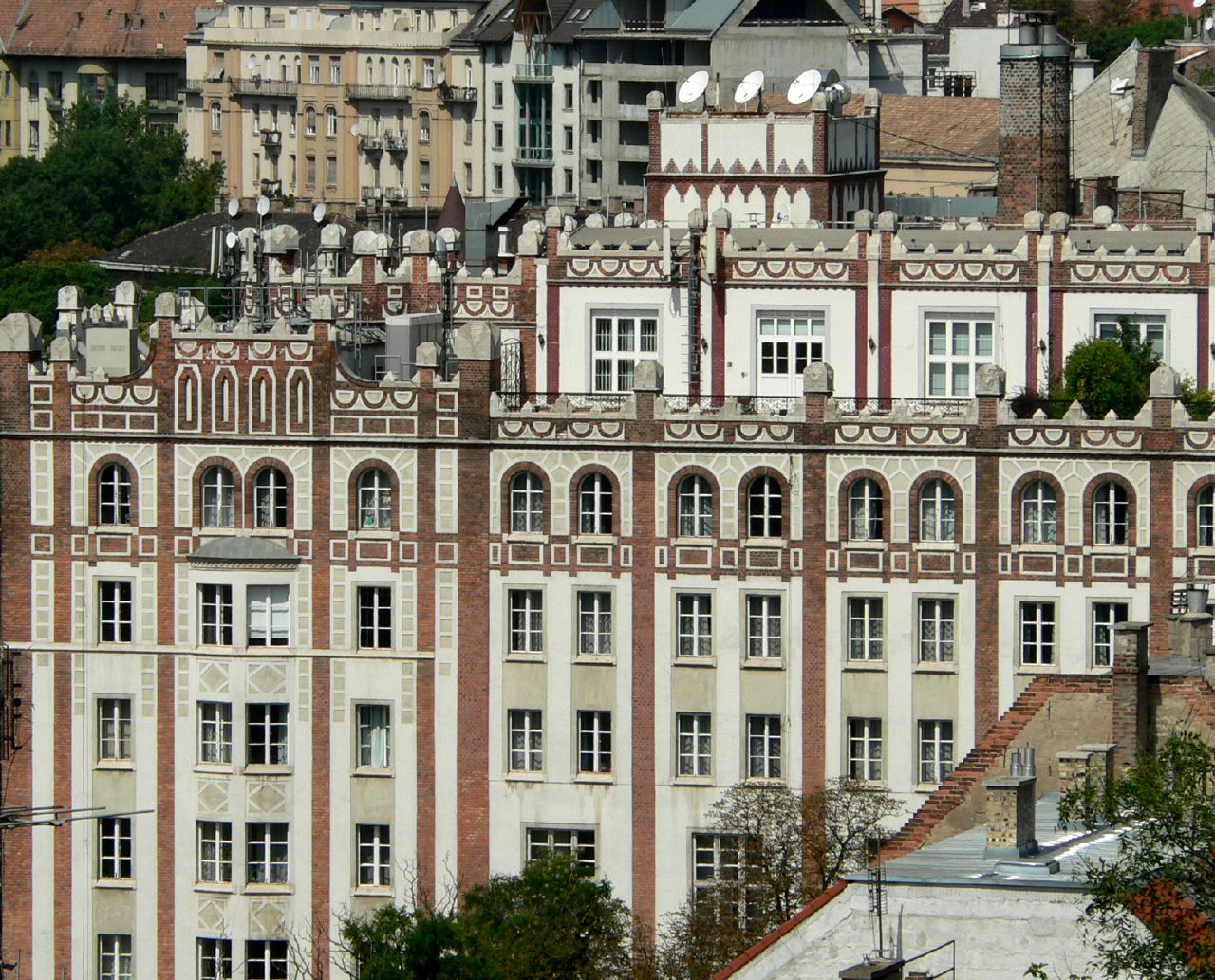 a tall building with lots of windows next to a hill