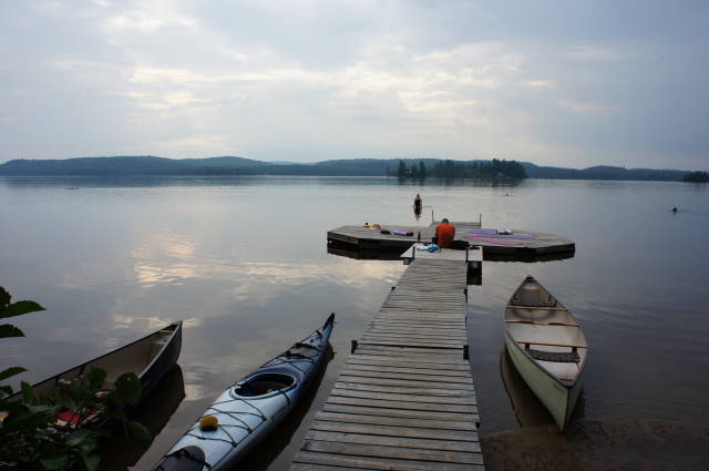 several kayaks tied up at the end of a wooden dock