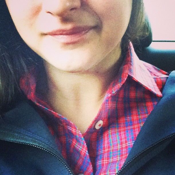 a woman wearing a red and blue plaid shirt