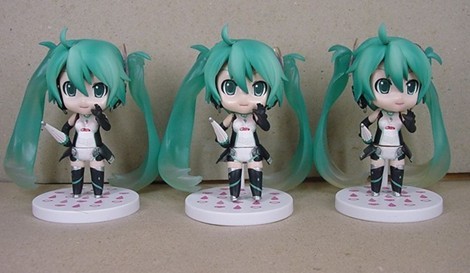 three figurines of anime characters stand side by side