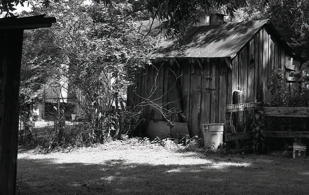 an old dilapidated shack is next to the fence