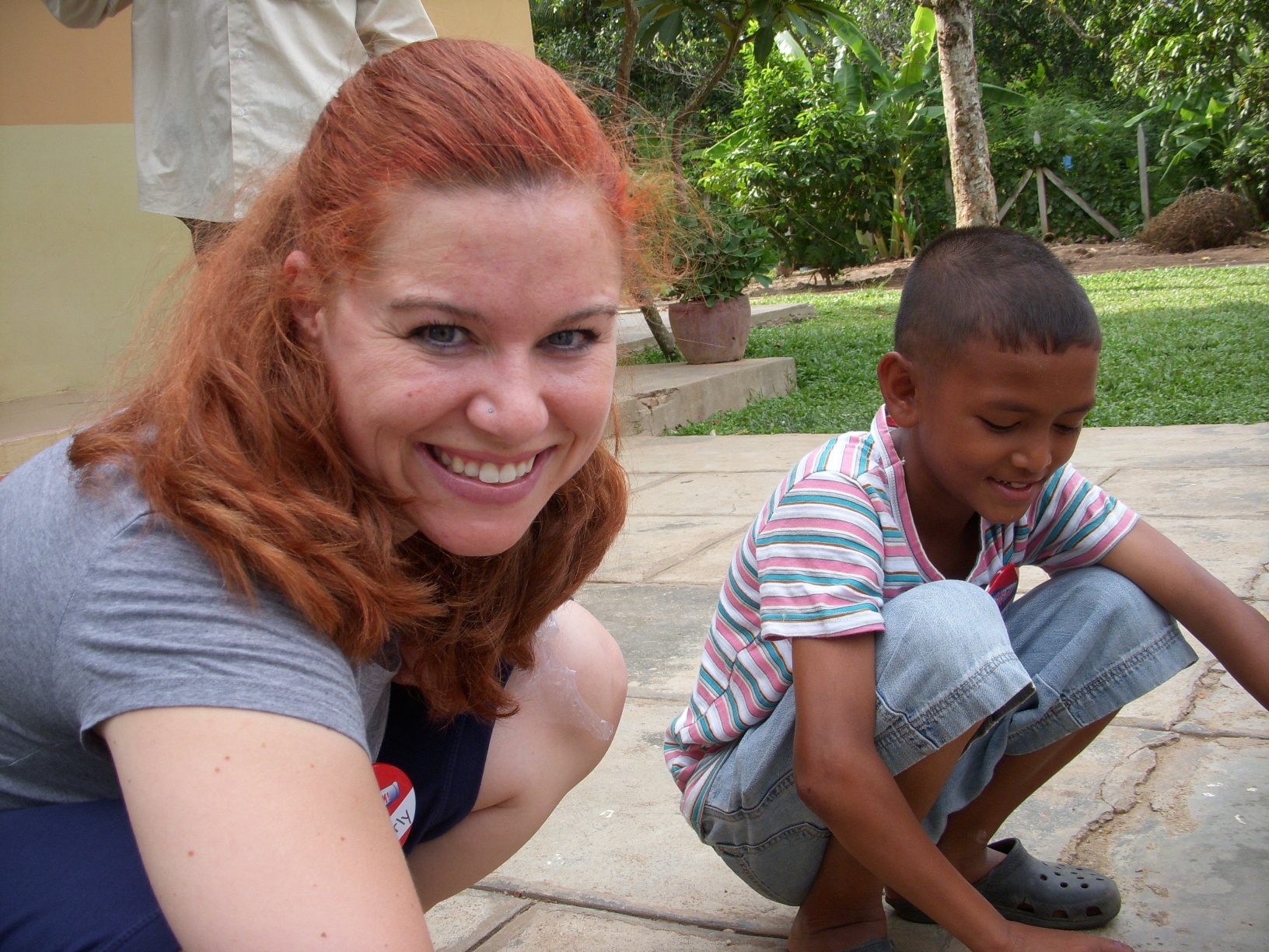 a woman and a boy playing with a green skateboard