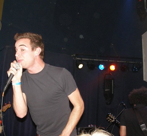 a young man holding a microphone up to his mouth