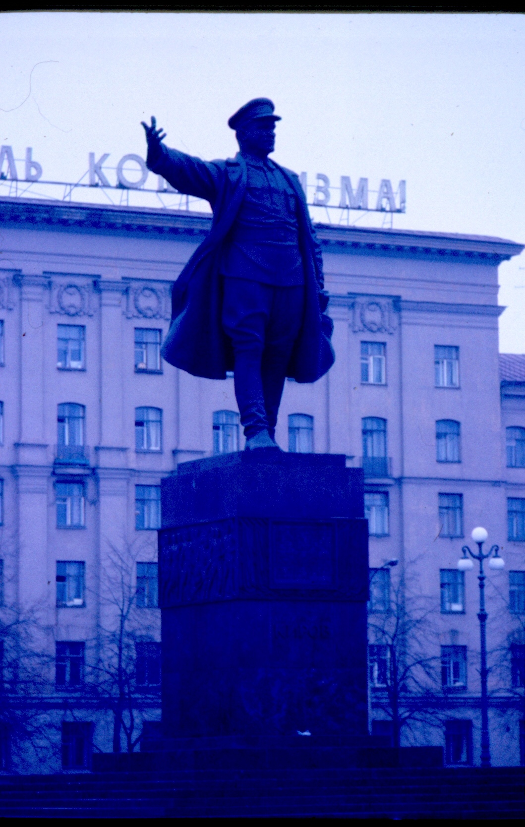 the large statue stands outside a tall building