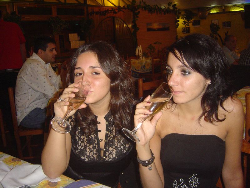 a close up of two young women drinking wine