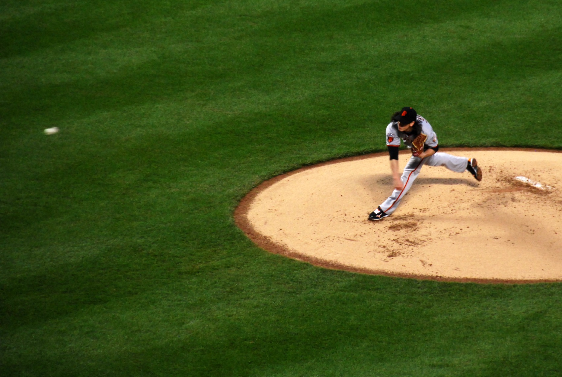 a baseball player pitching a ball in a baseball field