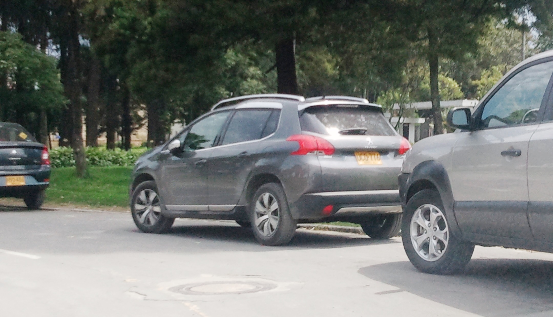 a gray car is parked near another one behind it