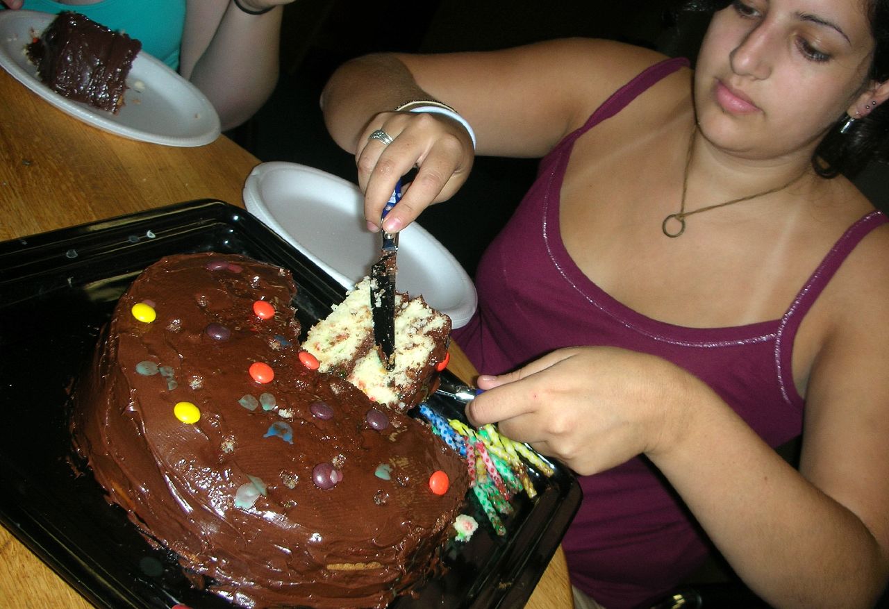 a woman  into a birthday cake with candles