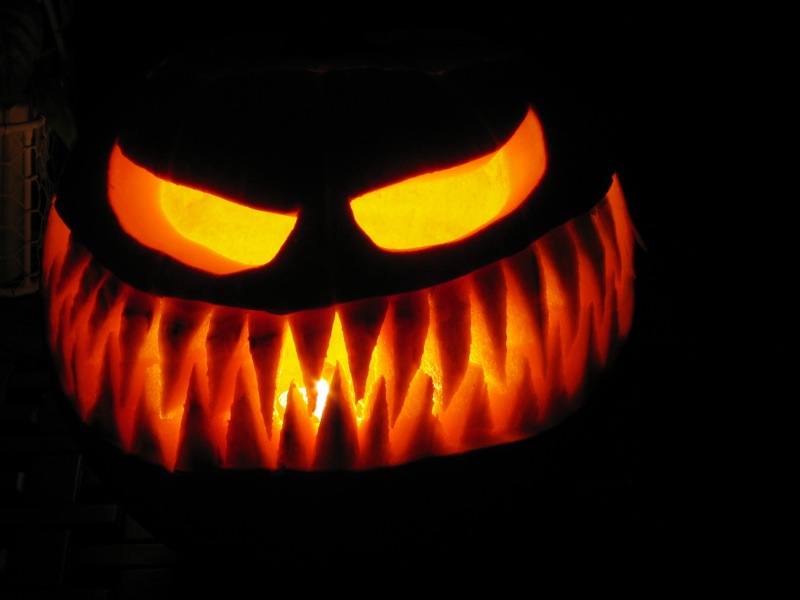 a carved pumpkin with glowing eyes in the dark