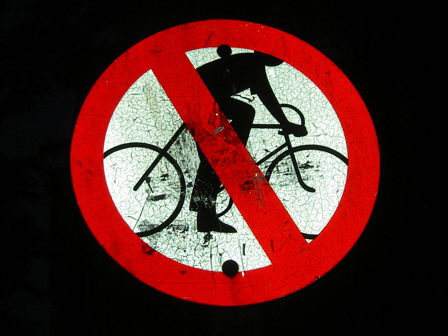 a red and white sign with a cyclist