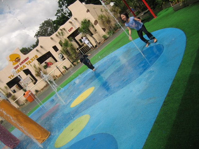 two children playing in the water at a play ground