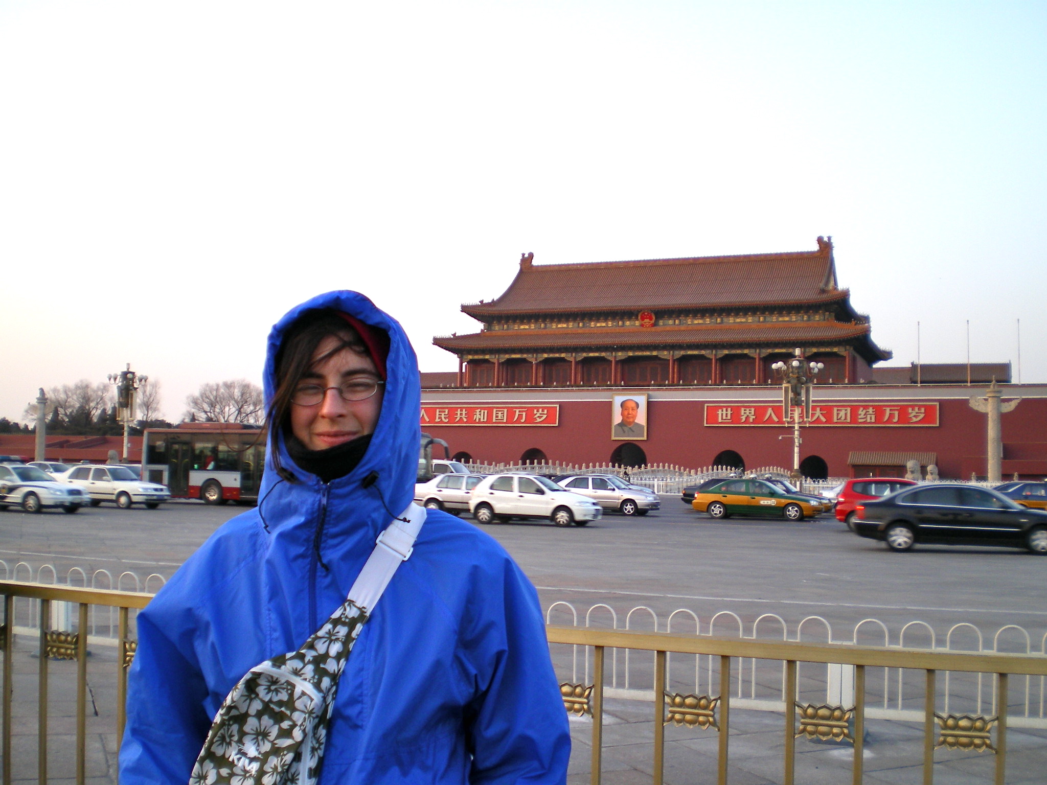 a woman with a blue coat stands in front of a building