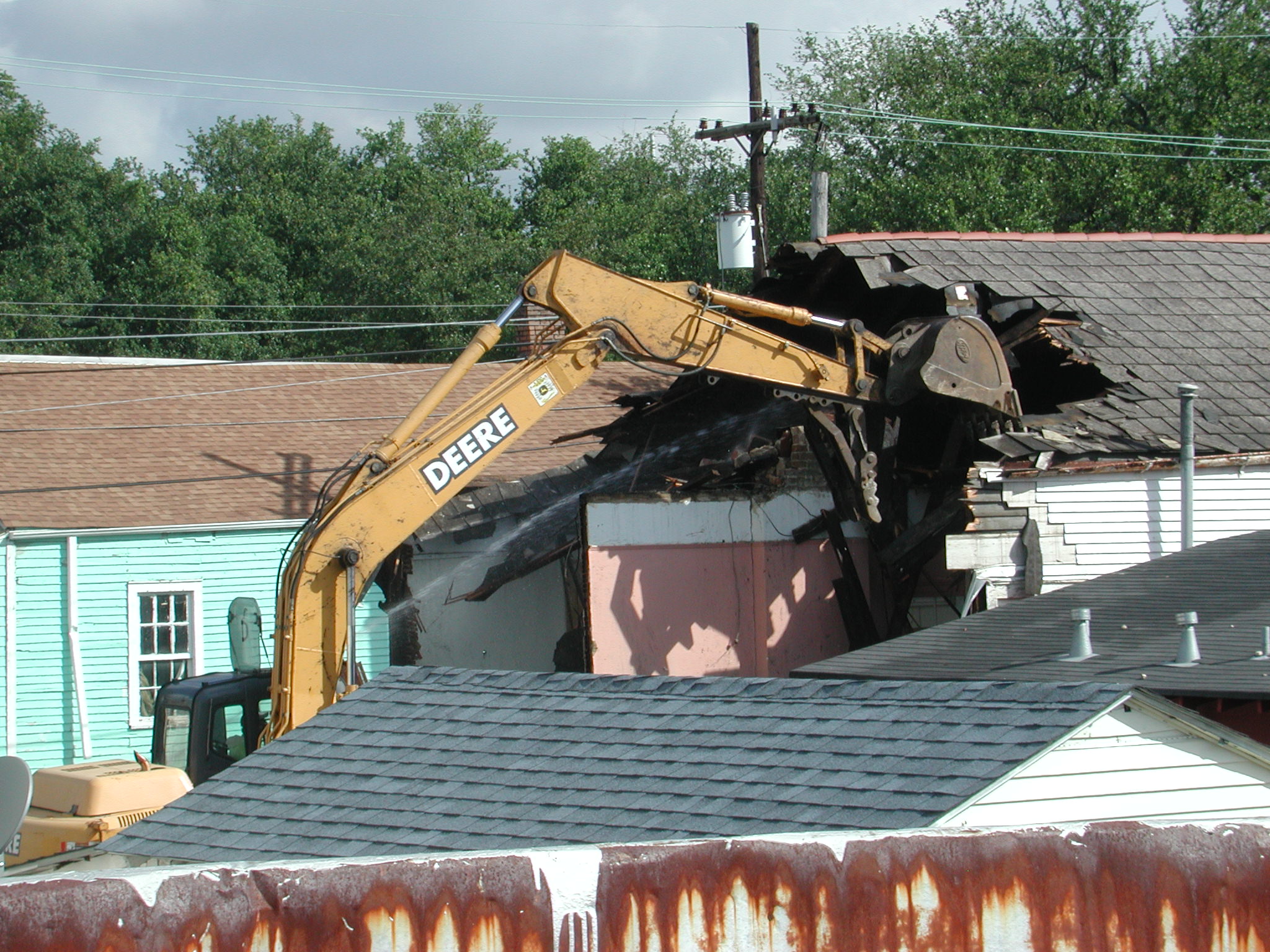 a tractor working on the top of a roof with no people around