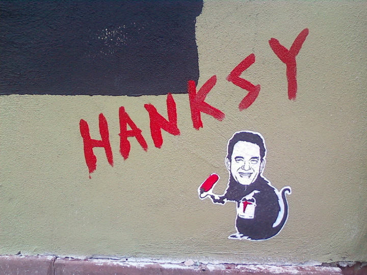 graffiti on the side of a building depicting an image of a man holding a small brush