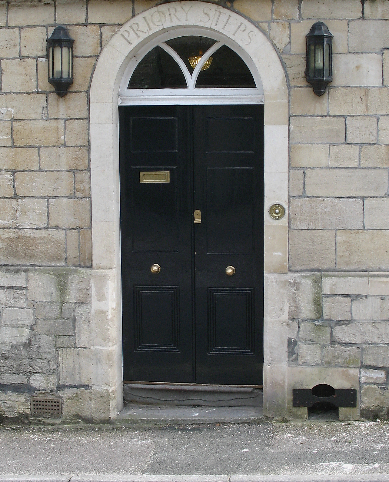 a black door sits between two stone arches