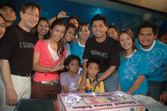 a group of people posing with a cake