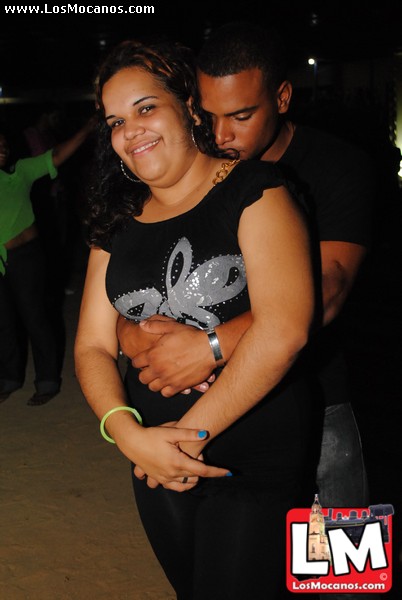 a smiling woman hugging a man in black shirt