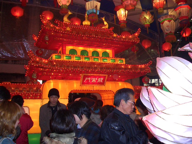 several people gathered in front of a lit up temple