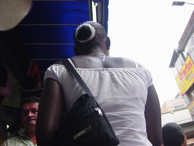 an older person holds a black purse with white hair on it