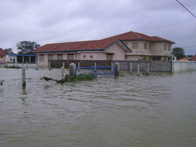a flooded street with houses in the distance