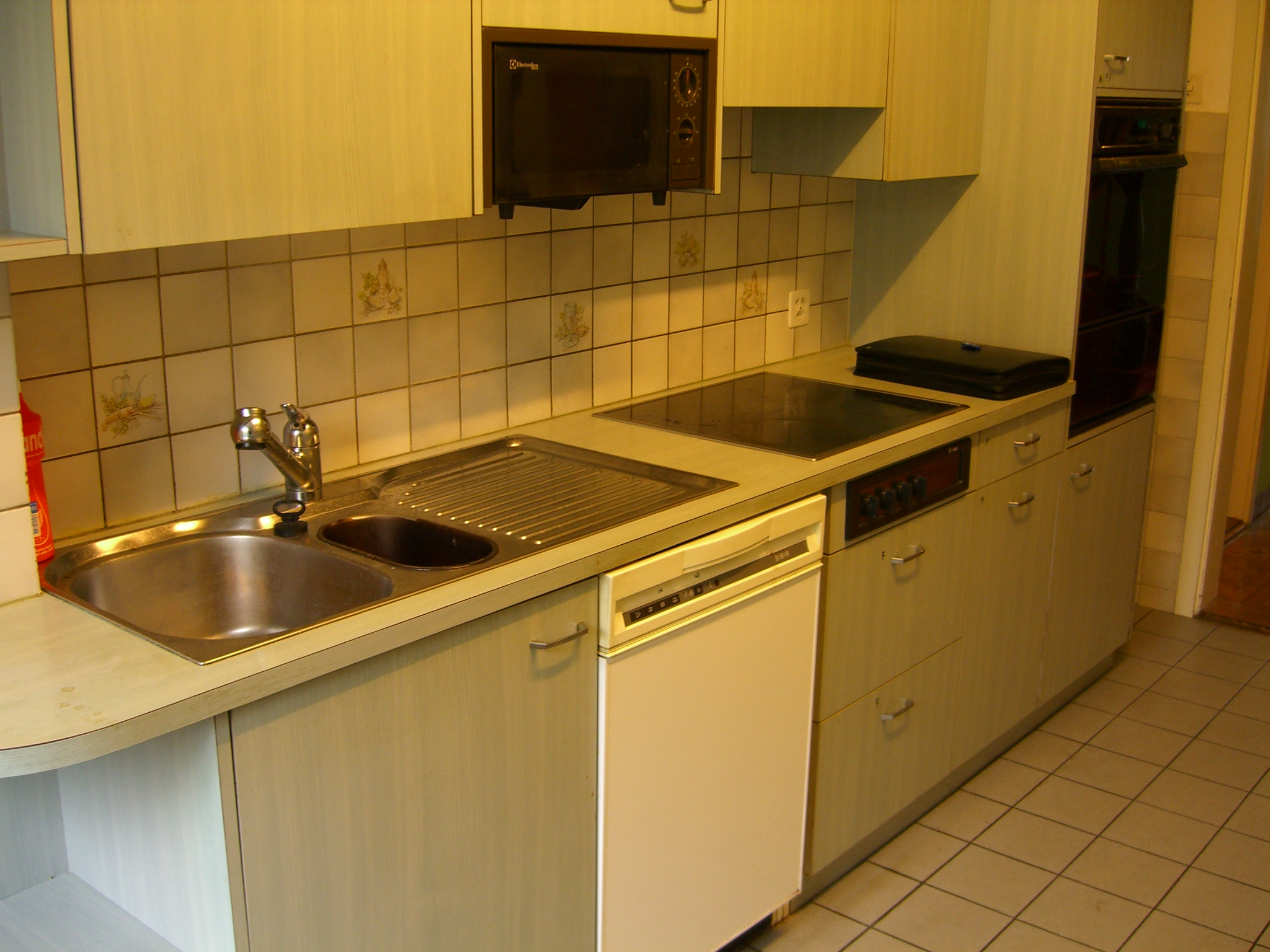 the kitchen has beige cabinets and counters with beige tile