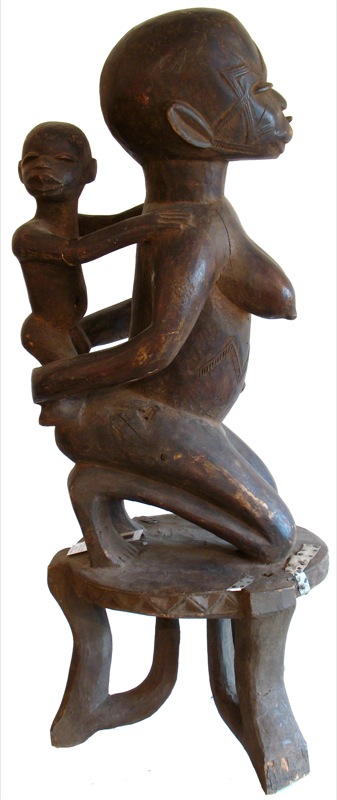a wooden statue with an adult and child on a bench