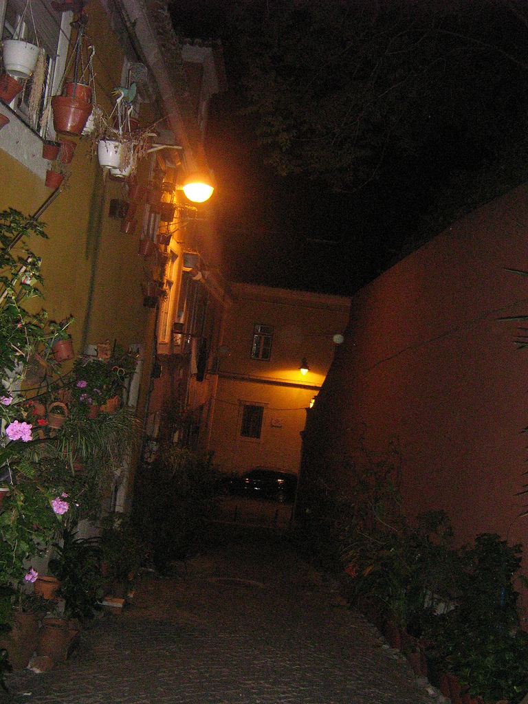 dark street with house light at end at night