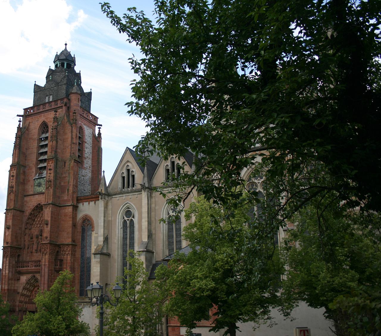 a picture of a church with tall buildings and green trees